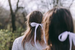 Portret die van twee mooie jonge zusters in de groene de lentetuin, op het gebied in de zonneschijn koesteren Hebbend pret samen, royalty-vrije stock fotografie Portret die van twee mooie jonge zusters in de groene de lentetuin, op het gebied in de zonneschijn koesteren Hebbend pret samen, royalty-vrije stock fotografie