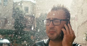 Portret gniewny mężczyzna krzyczy przy somebody z eyeglasses podczas gdy opowiadający na telefonie komórkowym w deszczu 4k materi zbiory Portret gniewny mężczyzna krzyczy przy somebody z eyeglasses podczas gdy opowiadający na telefonie komórkowym w deszczu 4k materi zbiory