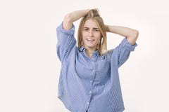 Portret młoda rozochocona blondynki kobieta jest ubranym błękitną koszula przeciw białemu tłu obrazy stock Portret młoda rozochocona blondynki kobieta jest ubranym błękitną koszula przeciw białemu tłu obrazy stock