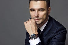 Portret mężczyzna obsiadanie z kostiumem z zegarkiem, studio fotografia royalty free Portret mężczyzna obsiadanie z kostiumem z zegarkiem, studio fotografia royalty free