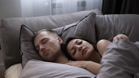Portret młody caucasian pary dosypianie w łóżku na popielatych łóżkowych prześcieradłach w domu Ranku czas zdjęcie wideo Portret młody caucasian pary dosypianie w łóżku na popielatych łóżkowych prześcieradłach w domu Ranku czas zdjęcie wideo