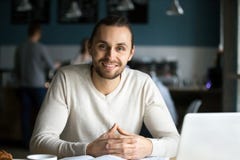 Portret uśmiechnięty męskiego ucznia studiowanie w za kawiarni fotografia stock Portret uśmiechnięty męskiego ucznia studiowanie w za kawiarni fotografia stock