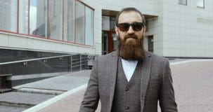 Portret van de aantrekkelijke modieuze jonge mens die de camera en het glimlachen onderzoeken stock videobeelden Portret van de aantrekkelijke modieuze jonge mens die de camera en het glimlachen onderzoeken stock videobeelden