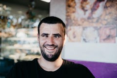 Portret van de grappige schele nerdmens die tot grappig gezicht met maken oorringen in zijn oren stock fotografie Portret van de grappige schele nerdmens die tot grappig gezicht met maken oorringen in zijn oren stock fotografie