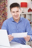 Portret van de Jonge Mens die Binnenlandse Rekeningen bekijken stock foto Portret van de Jonge Mens die Binnenlandse Rekeningen bekijken stock foto