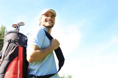 Portret van de mannelijke zak van het golfspeler dragende golf terwijl het lopen door groen gras van golfclub stock afbeeldingen Portret van de mannelijke zak van het golfspeler dragende golf terwijl het lopen door groen gras van golfclub stock afbeeldingen