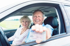 Portret van een gelukkige hogere mens die zijn rijbewijs tonen terwijl stock fotografie Portret van een gelukkige hogere mens die zijn rijbewijs tonen terwijl stock fotografie