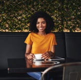 Portret van een het glimlachen jonge vrouwenzitting in koffie royalty-vrije stock foto's Portret van een het glimlachen jonge vrouwenzitting in koffie royalty-vrije stock foto's