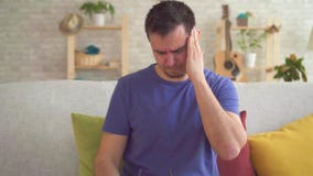 Portret van een jonge mens met een hoofdpijn stock video Portret van een jonge mens met een hoofdpijn stock video