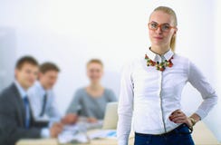 Portret van een jonge vrouw die op kantoor werken die zich met omslag bevinden Stock Foto Portret van een jonge vrouw die op kantoor werken die zich met omslag bevinden Stock Foto