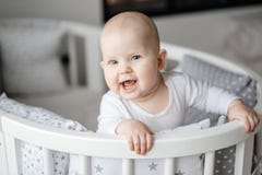 Portret van een kind die in zijn baby wieg en het glimlachen blijven stock foto Portret van een kind die in zijn baby wieg en het glimlachen blijven stock foto