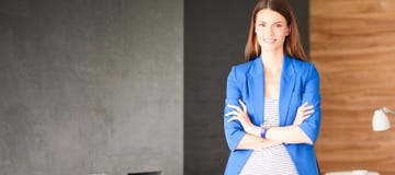 Portret van een mooie bedrijfsvrouw die zich dichtbij haar werkplaats bevinden Stock Afbeelding Portret van een mooie bedrijfsvrouw die zich dichtbij haar werkplaats bevinden Stock Afbeelding