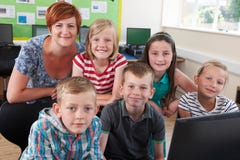 Portret van Elementaire Leerlingen in Computerklasse met Leraar stock afbeelding Portret van Elementaire Leerlingen in Computerklasse met Leraar stock afbeelding