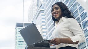 Portret van gelukkige de computerlaptop van het bedrijfs Afrikaanse vrouwengebruik binnen stock afbeelding Portret van gelukkige de computerlaptop van het bedrijfs Afrikaanse vrouwengebruik binnen stock afbeelding