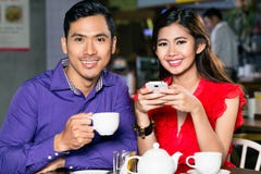 Portret van het jonge en gelukkige Aziatische paar ontspannen samen in koffiewinkel royalty-vrije stock afbeelding Portret van het jonge en gelukkige Aziatische paar ontspannen samen in koffiewinkel royalty-vrije stock afbeelding