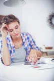 Portret van jonge vrouw die mobiele telefoon thuis met behulp van terwijl het hebben van ontbijt in keuken Royalty-vrije Stock Fotografie Portret van jonge vrouw die mobiele telefoon thuis met behulp van terwijl het hebben van ontbijt in keuken Royalty-vrije Stock Fotografie