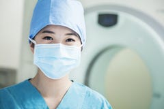 Portret van jonge vrouwelijke chirurg die chirurgisch masker in de werkende ruimte dragen stock afbeelding Portret van jonge vrouwelijke chirurg die chirurgisch masker in de werkende ruimte dragen stock afbeelding