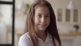 Portret van leuk meisje die camera bekijken die gelukkig glimlachen Onbezorgde kinderjaren Weinig emotioneel meisje thuis Echt stock footage Portret van leuk meisje die camera bekijken die gelukkig glimlachen Onbezorgde kinderjaren Weinig emotioneel meisje thuis Echt stock footage
