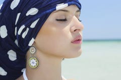 Portret van mooie vrouw in een blauwe sjaal op het strand. Arabische stijl stock fotografie Portret van mooie vrouw in een blauwe sjaal op het strand. Arabische stijl stock fotografie