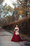 Porträt einer schönen Braut in einem roten Kleid mit einem Heiratsblumenstrauß in einer Hand stockfoto Porträt einer schönen Braut in einem roten Kleid mit einem Heiratsblumenstrauß in einer Hand stockfoto
