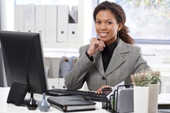 Porträt der glücklichen Geschäftsfrau am Schreibtisch lizenzfreies stockbild Porträt der glücklichen Geschäftsfrau am Schreibtisch lizenzfreies stockbild