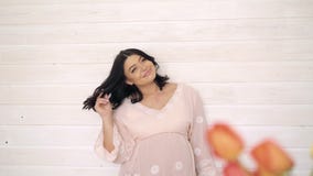 Porträt der glücklichen, lächelnden schwangeren jungen Frau auf beige Hintergrund 4K stock video footage Porträt der glücklichen, lächelnden schwangeren jungen Frau auf beige Hintergrund 4K stock video footage