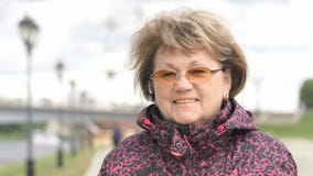 Porträt der lächelnden erwachsenen Frau alterte 60s draußen stock video Porträt der lächelnden erwachsenen Frau alterte 60s draußen stock video