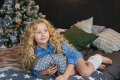 Porträt des blonden kleinen Mädchens im blauen Kleid liegt und schaut auf einem Bett in der Weihnachtsdunkelkammer Seiten stockfoto Porträt des blonden kleinen Mädchens im blauen Kleid liegt und schaut auf einem Bett in der Weihnachtsdunkelkammer Seiten stockfoto