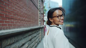 Porträt des hübschen Afroamerikanermädchens, das Kamera geht draußen dann, betrachtend stock video Porträt des hübschen Afroamerikanermädchens, das Kamera geht draußen dann, betrachtend stock video