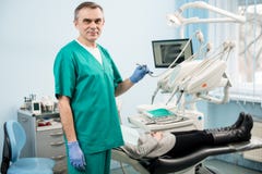 Porträt des hübschen männlichen Zahnarztes mit zahnmedizinischen Werkzeugen in der zahnmedizinischen Klinik Stockbild Porträt des hübschen männlichen Zahnarztes mit zahnmedizinischen Werkzeugen in der zahnmedizinischen Klinik Stockbild