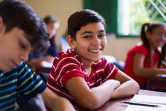 Porträt des Schuljungen Kamera in der Klasse betrachtend lizenzfreies stockfoto Porträt des Schuljungen Kamera in der Klasse betrachtend lizenzfreies stockfoto