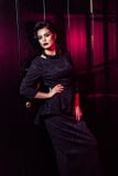 Porträt des schönen Mode-Modells im klassischen schwarzen Kleid, im Make-up und in der Frisur nahe dunkler Türstellung und -aufst lizenzfreies stockfoto Porträt des schönen Mode-Modells im klassischen schwarzen Kleid, im Make-up und in der Frisur nahe dunkler Türstellung und -aufst lizenzfreies stockfoto