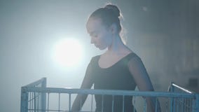 Porträt des würdevollen Berufsballerinatanzens im schwarzen Kleid im Studio innerhalb des blauen Käfigs im Scheinwerfer auf a stock video footage Porträt des würdevollen Berufsballerinatanzens im schwarzen Kleid im Studio innerhalb des blauen Käfigs im Scheinwerfer auf a stock video footage