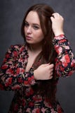 Porträt einer Frau in einem farbigen Kleid auf grauem Hintergrund lizenzfreie stockbilder Porträt einer Frau in einem farbigen Kleid auf grauem Hintergrund lizenzfreie stockbilder