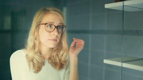 Porträt einer jungen Frau, die auf Gläsern versucht und sie annimmt stock footage Porträt einer jungen Frau, die auf Gläsern versucht und sie annimmt stock footage