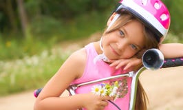 Porträt eines kleinen Mädchens in einem Schutzhelm steuert ihr Fahrrad und hält einen Blumenstrauß von Gänseblümchen stockfotos Porträt eines kleinen Mädchens in einem Schutzhelm steuert ihr Fahrrad und hält einen Blumenstrauß von Gänseblümchen stockfotos