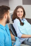 Porträt eines männlichen Zahnarztes und des jungen glücklichen weiblichen Patienten stockfotografie Porträt eines männlichen Zahnarztes und des jungen glücklichen weiblichen Patienten stockfotografie