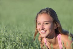 Porträt eines schönen Jugendlichmädchens, das in einer Wiese lächelt stockbild Porträt eines schönen Jugendlichmädchens, das in einer Wiese lächelt stockbild
