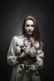 Porträt eines schönen Vampirs mit Rosebud lizenzfreie stockfotos Porträt eines schönen Vampirs mit Rosebud lizenzfreie stockfotos