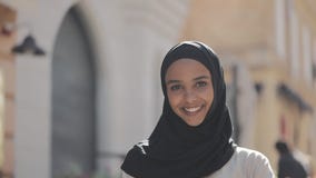 Porträt junge schöne moslemische Frau des tragenden hijab Kopftuchlachens nett in der alten Stadt Abschluss oben stock footage Porträt junge schöne moslemische Frau des tragenden hijab Kopftuchlachens nett in der alten Stadt Abschluss oben stock footage