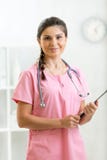 Porträt von Doktorfrau mit Klemmbrett im Büro lizenzfreie stockbilder Porträt von Doktorfrau mit Klemmbrett im Büro lizenzfreie stockbilder