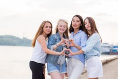 Porträt von vier jungen Studentenmädchen, die Finger zeigen, gestikulieren Herz lizenzfreie stockfotografie Porträt von vier jungen Studentenmädchen, die Finger zeigen, gestikulieren Herz lizenzfreie stockfotografie