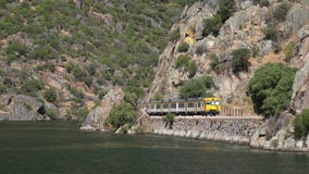 Portuguese railway known as Linha do Douro traveling alongside the river Douro in Portugal. On the narrow tracks carved into the river bank stock video footage Portuguese railway known as Linha do Douro traveling alongside the river Douro in Portugal. On the narrow tracks carved into the river bank stock video footage