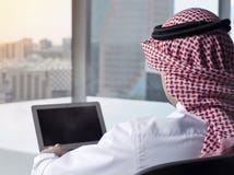 Portátil de observação do homem saudita no projeto do trabalho fotografia de stock Portátil de observação do homem saudita no projeto do trabalho fotografia de stock