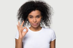Posa di mostra femminile africana felice del segno di approvazione sopra lo spazio in bianco grigio fotografia stock libera da diritti Posa di mostra femminile africana felice del segno di approvazione sopra lo spazio in bianco grigio fotografia stock libera da diritti