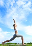 Posa di pratica del guerriero di yoga della donna. fotografia stock Posa di pratica del guerriero di yoga della donna. fotografia stock