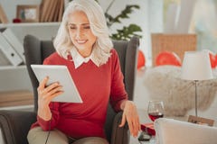 Positieve bejaarde damezitting als voorzitter met tablet royalty-vrije stock afbeeldingen Positieve bejaarde damezitting als voorzitter met tablet royalty-vrije stock afbeeldingen