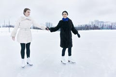 Positive junge Frauen auf Eisbahn lizenzfreies stockbild Positive junge Frauen auf Eisbahn lizenzfreies stockbild