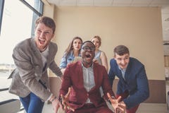 Positive Kollegen, die Spaß mit Bürostühlen haben stockfoto Positive Kollegen, die Spaß mit Bürostühlen haben stockfoto