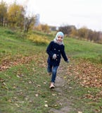 A photo of a smiling little girl running on a path in an autumn park stock photos A photo of a smiling little girl running on a path in an autumn park stock photos